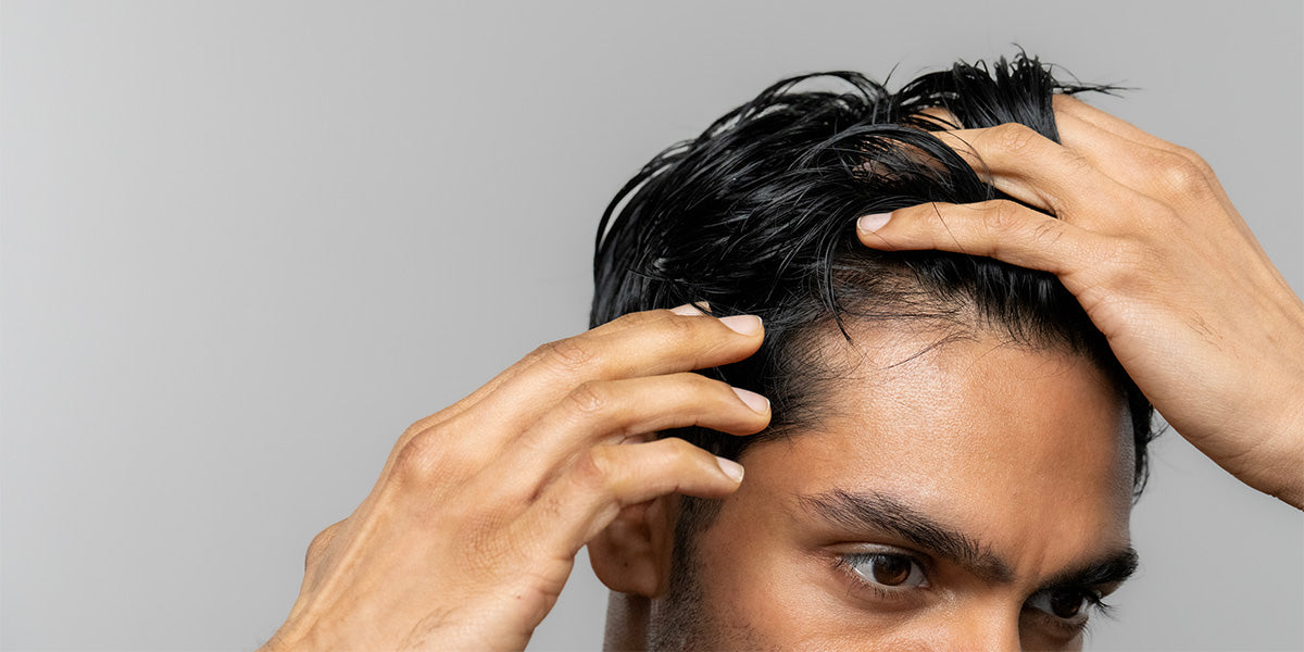 Man examining his hairline for signs of receding.