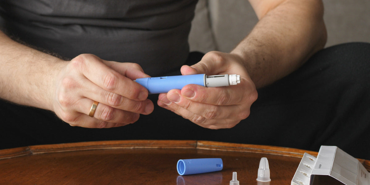 Closeup of man holding Ozempic treatment in his hands.