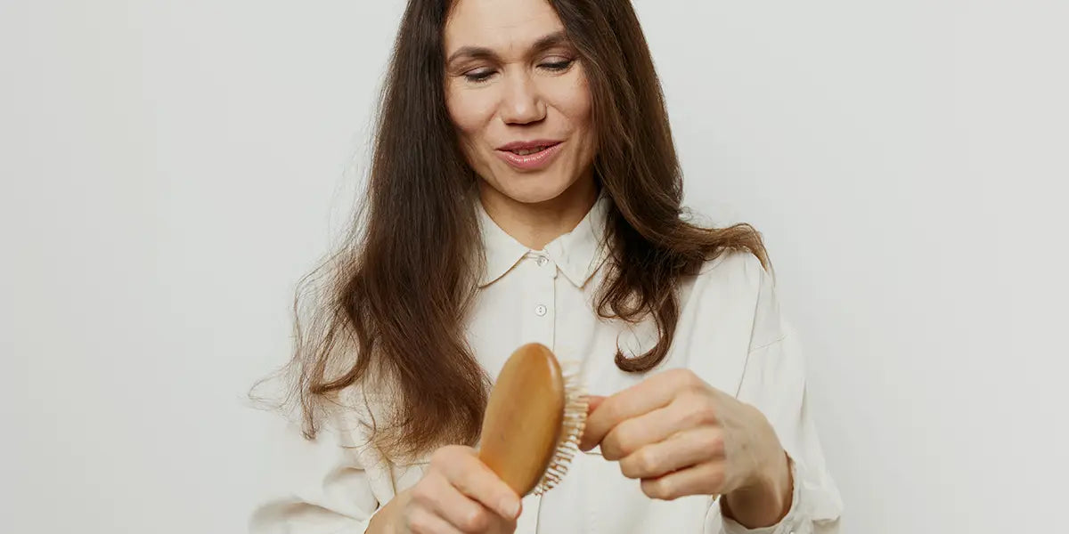 Woman combing hair needing spironolactone for hair loss.