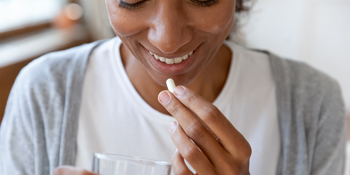 Woman taking vitamins for hair loss.