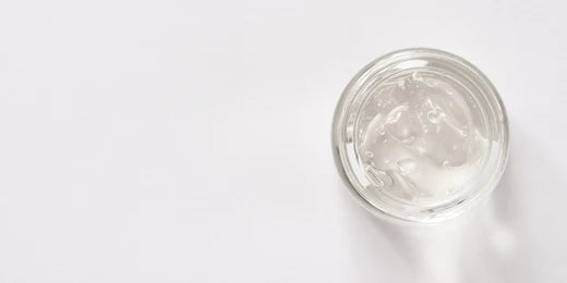 Clear gel in a pot against a white background.