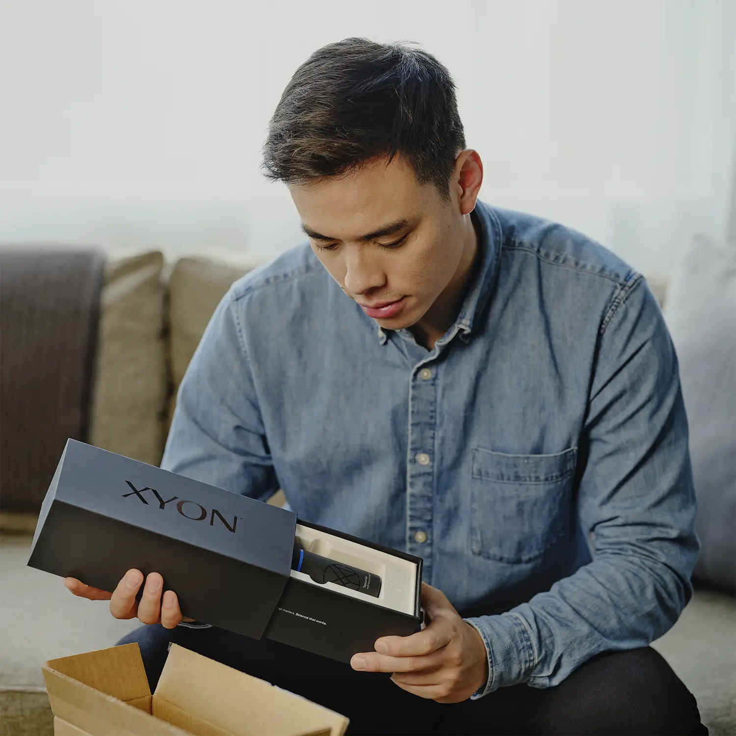 a man unboxing his hair loss treatment from xyon