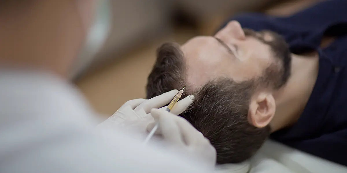 Brunette man receiving dutasteride mesotherapy injection for hair loss.