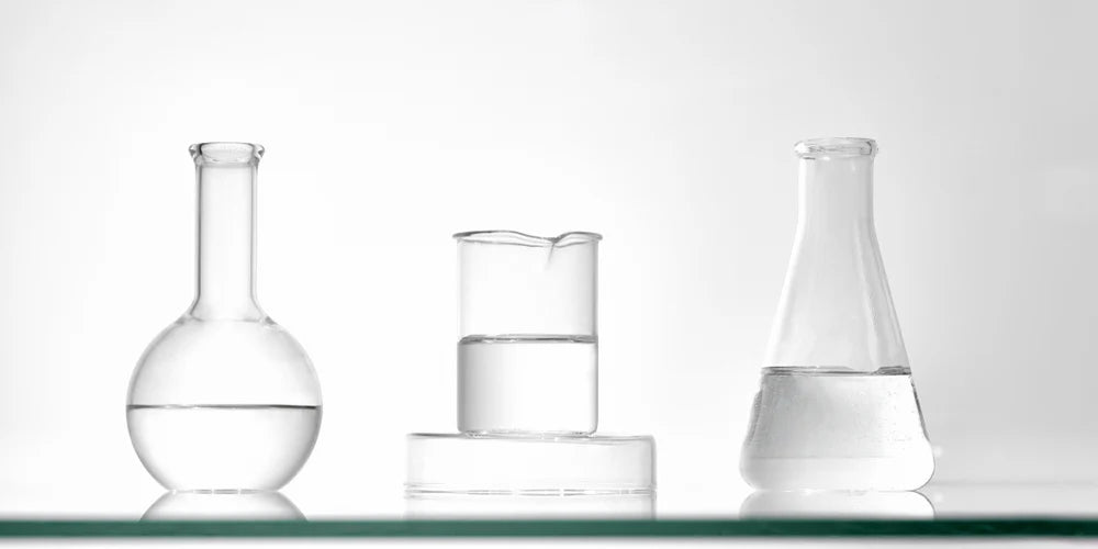 Image of 3 scientific beakers with clear liquids in them. 