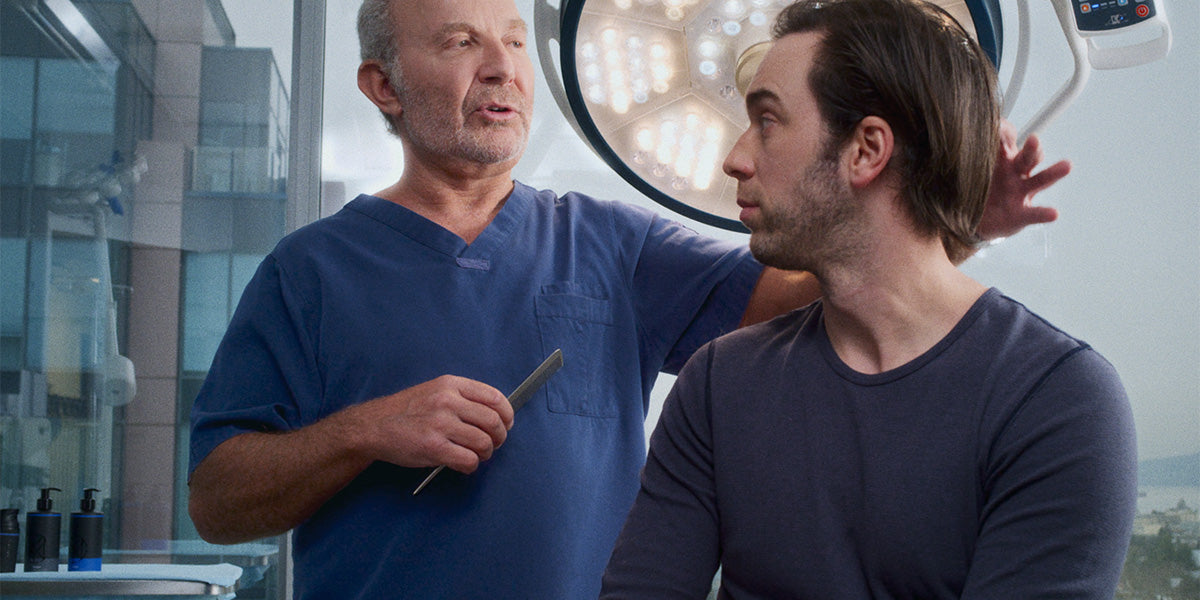 Doctor examining his young patient's hairline.