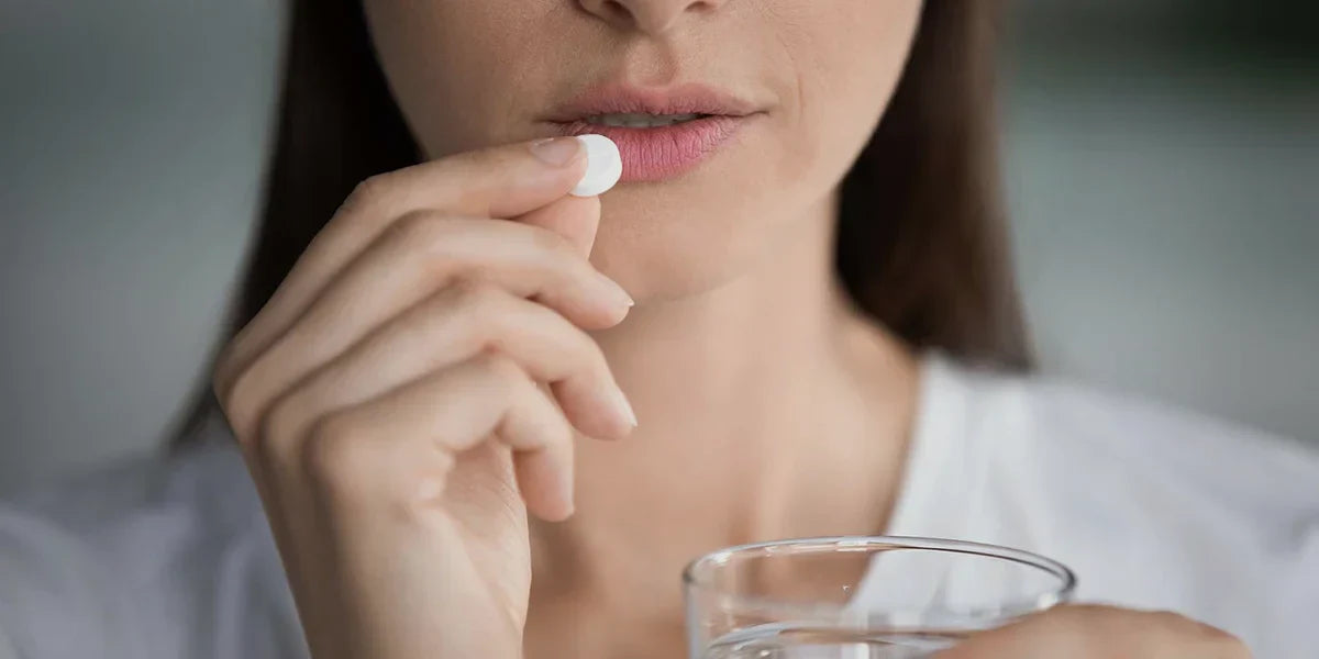 Young woman taking tablet of dutasteride for female hair loss.