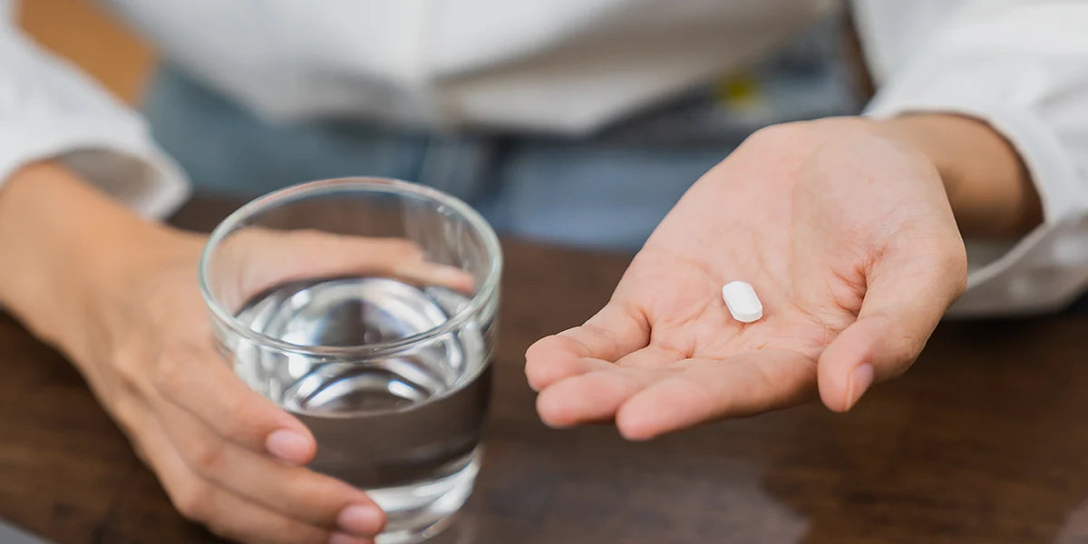 Hand holding spironolactone tablet for PCOS treatment.