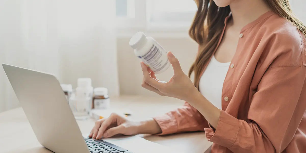 Young woman reading medication label for finasteride for women.