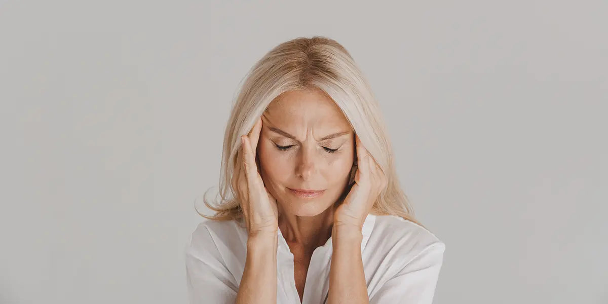 Mature woman with headache, one of the finasteride side effects in women.