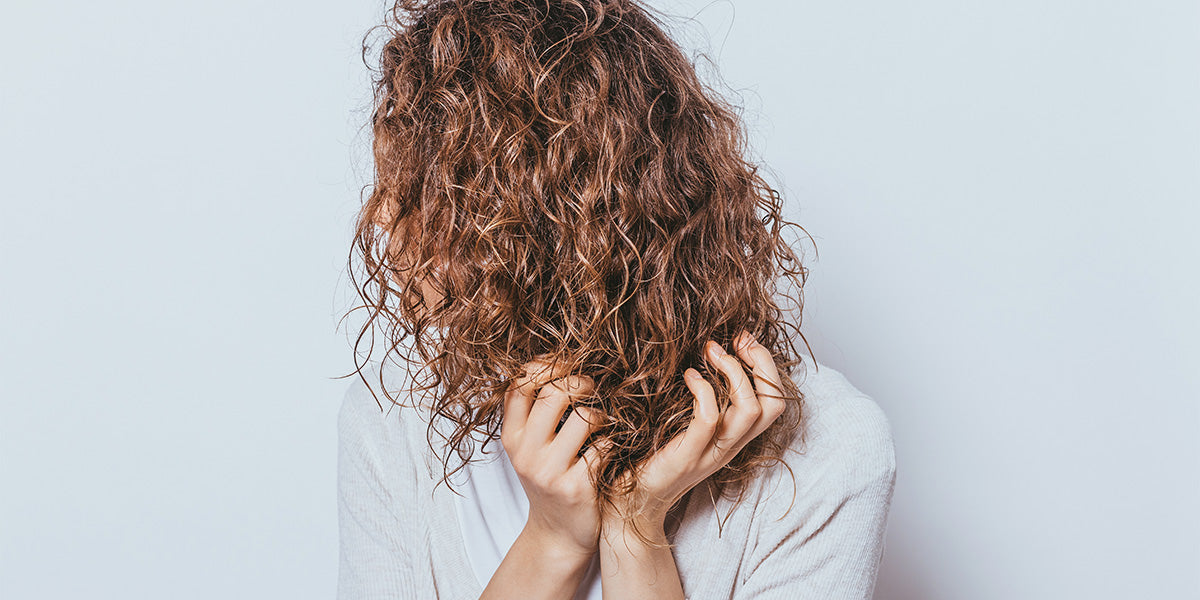 Young woman with tight curly hair type.