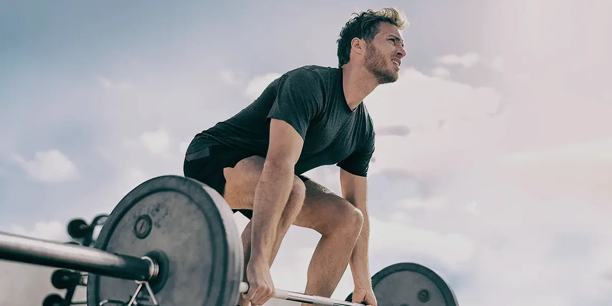 Young man lifting weights exploring relationship between working out and hair loss