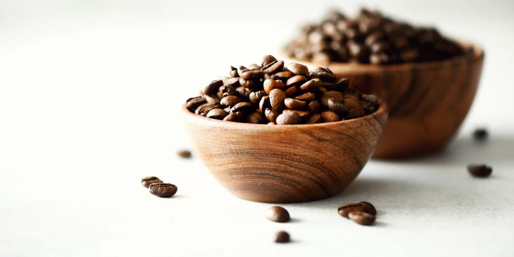 Image of bowls full of coffee beans, with some beans spilling out.