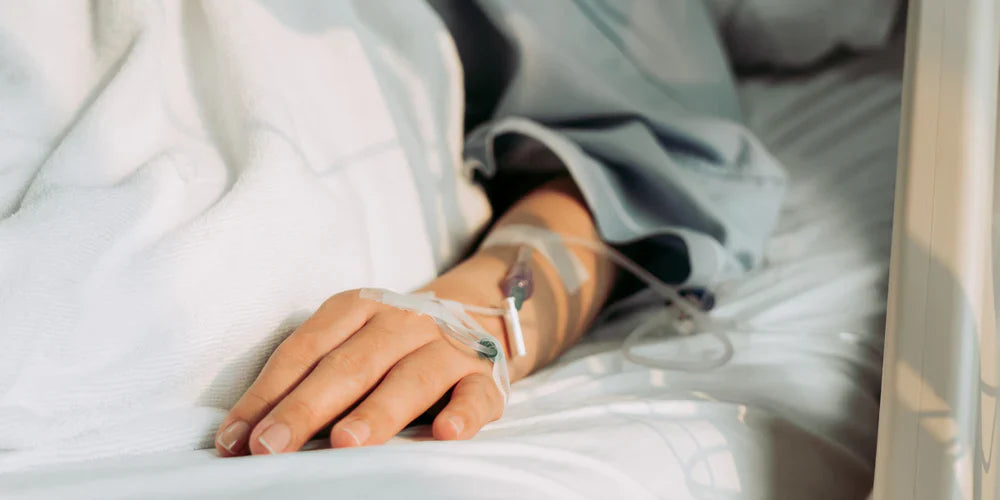 Image of person laying down with arm receiving IV medications, in view.