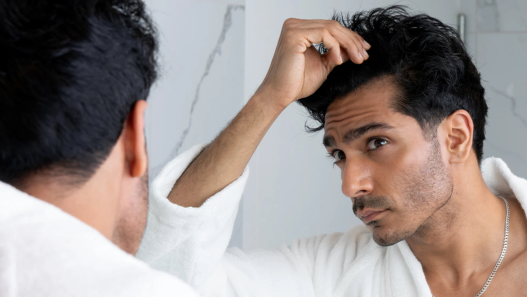 man inspecting his hairline 